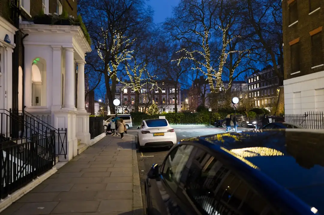 Rue résidentielle haut de gamme de Londres avec maisons victoriennes et entrée d’un immeuble contemporain.