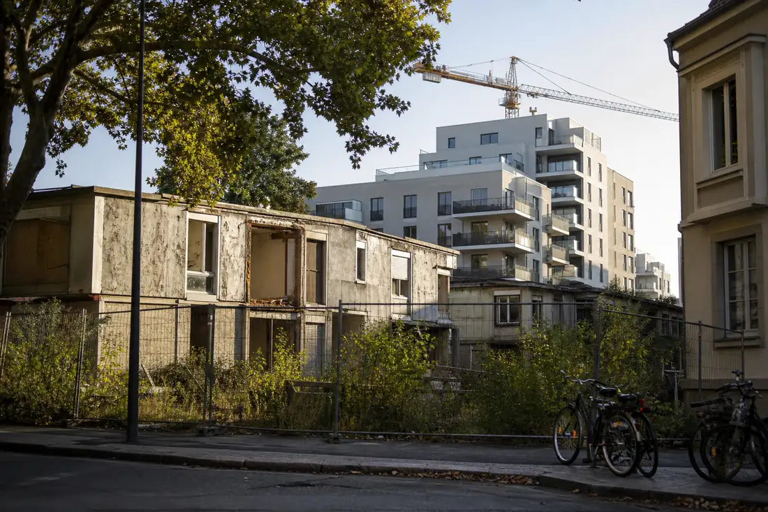 Ancien ensemble résidentiel en reconversion, devant un chantier de logements neufs dans une rue de Torfou.