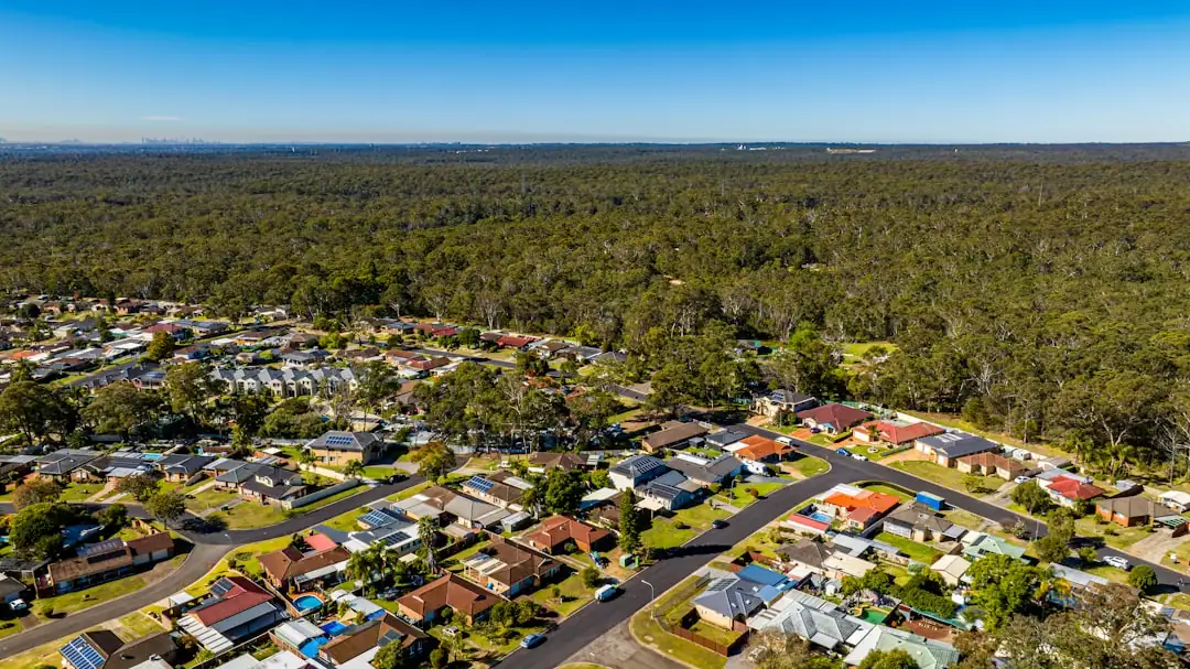 Petit ensemble immobilier isolé dans l’arrière-pays australien, avec bâtiments bas, piste et eucalyptus.
