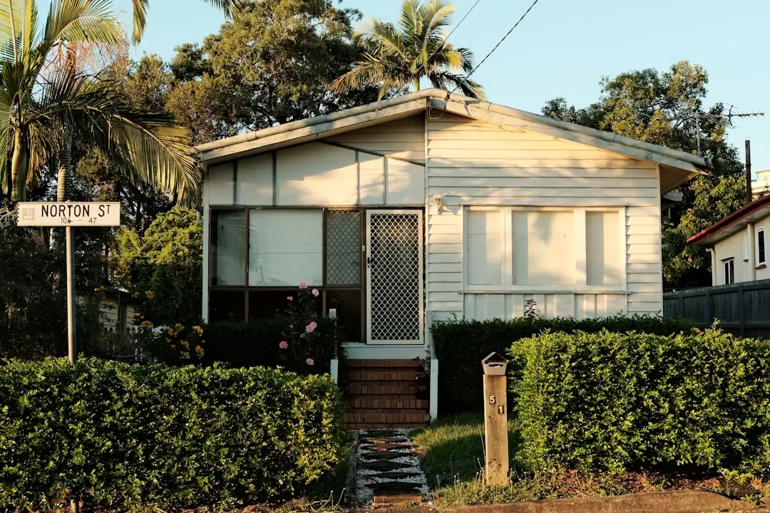 Petit ensemble immobilier isolé dans l’arrière-pays australien, avec route poussiéreuse et bâtiments bas.