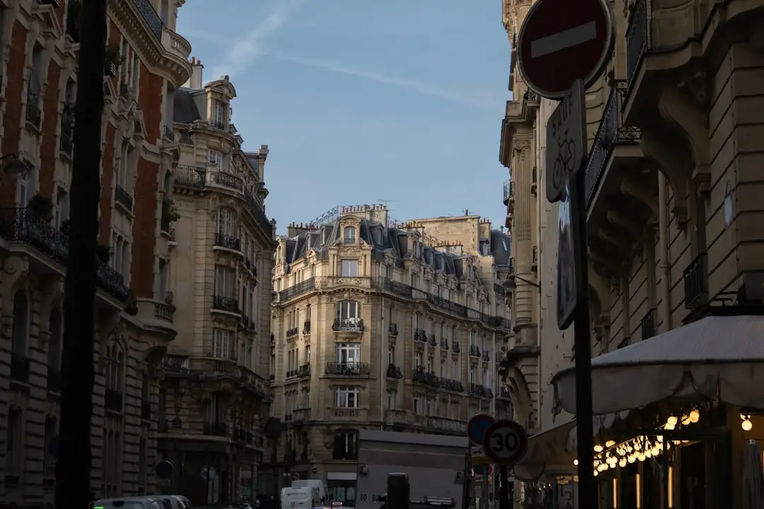 Conseiller immobilier préparant un dossier de visite dans une agence parisienne sans annonces en vitrine.