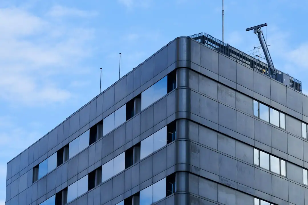 Dossiers de financement immobilier commercial examinés dans un bureau face à un quartier d’affaires.
