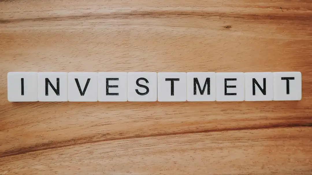 Équipe d’investissement immobilier examinant plans d’immeuble et données financières autour d’une table de réunion.