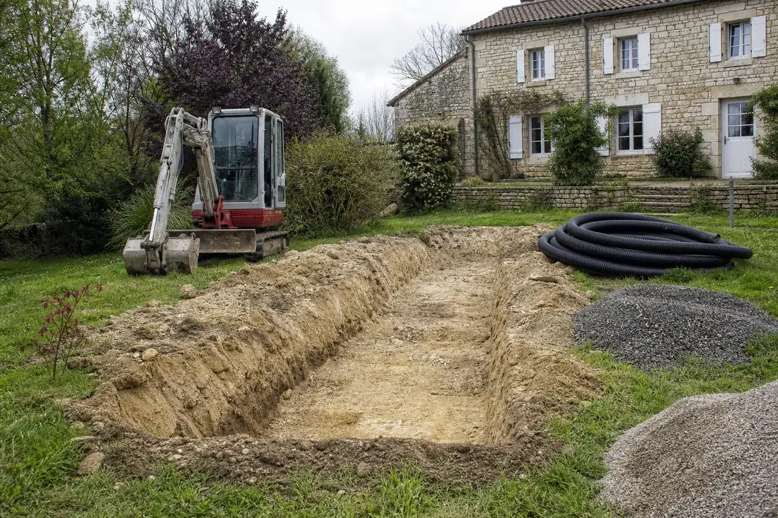 Tranchée ouverte dans le jardin d’une maison de campagne pour la pose d’un assainissement individuel