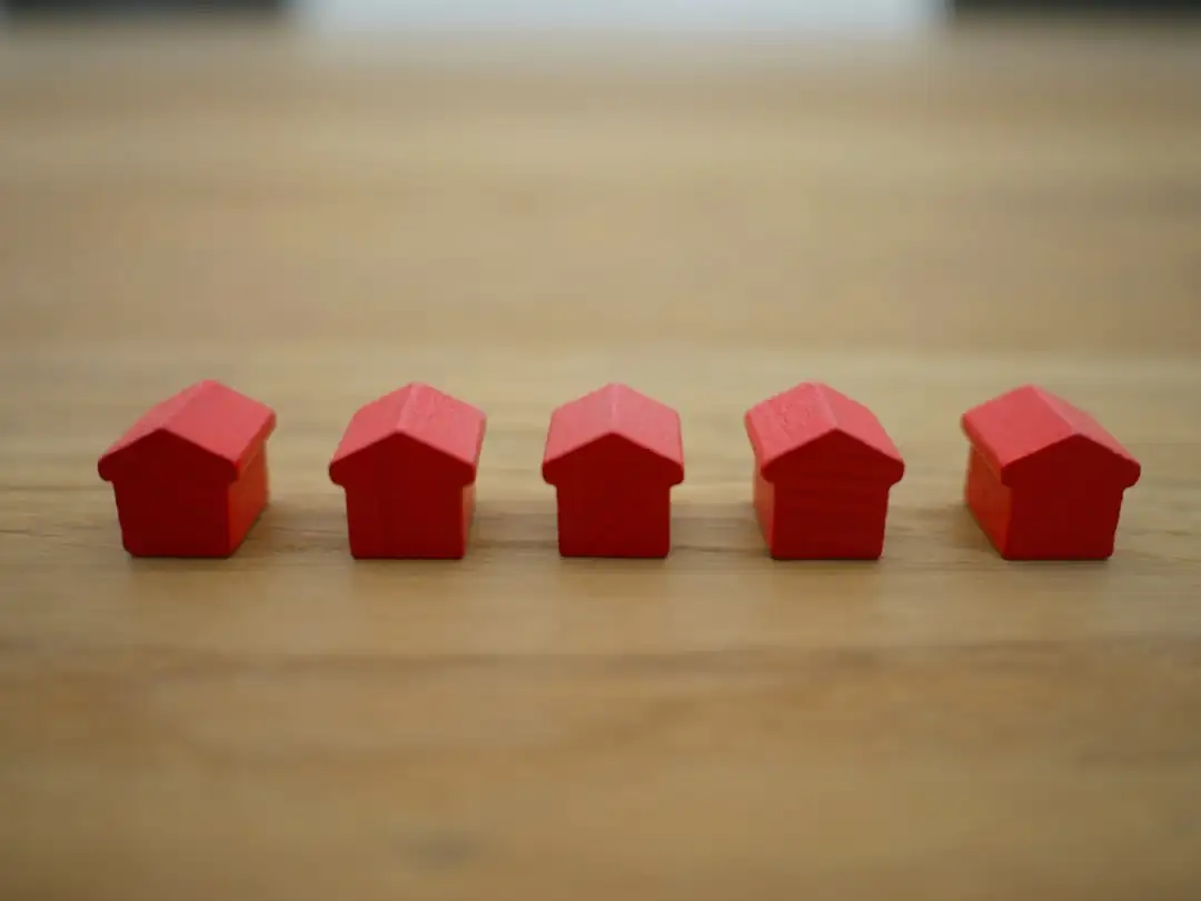 Dossier de prêt, ordinateur et téléphone posés sur une table lors d’une vérification de financement immobilier.