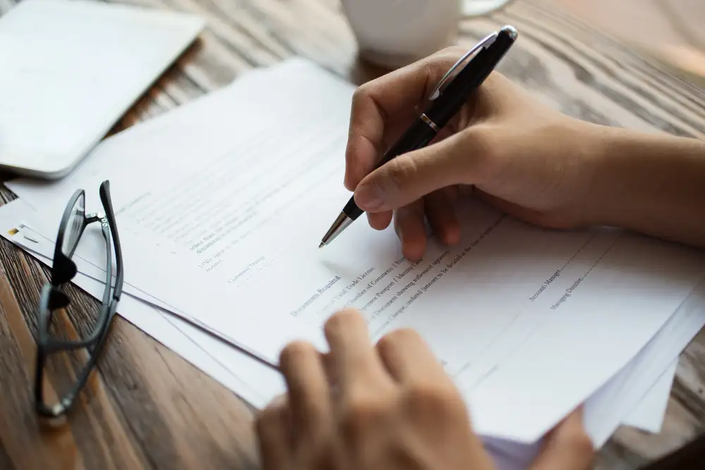 Couple examinant un plan de logement avec un conseiller dans un quartier résidentiel contemporain de Rennes.