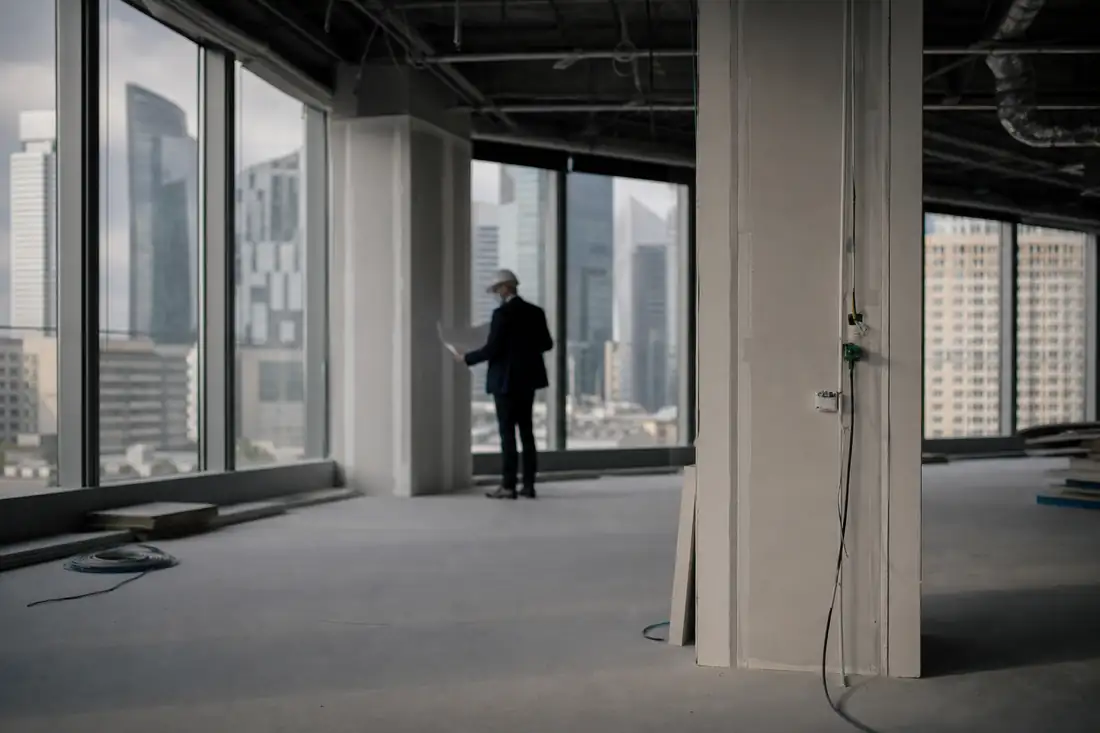 Plateau de bureaux vacant et rénové dans un immeuble francilien, avec vue urbaine et postes de travail.
