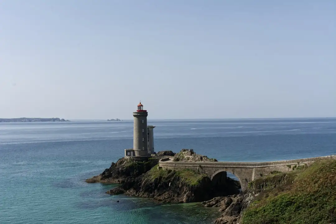 Investisseur observant des immeubles résidentiels dans une ville bretonne proche du littoral, par temps couvert.