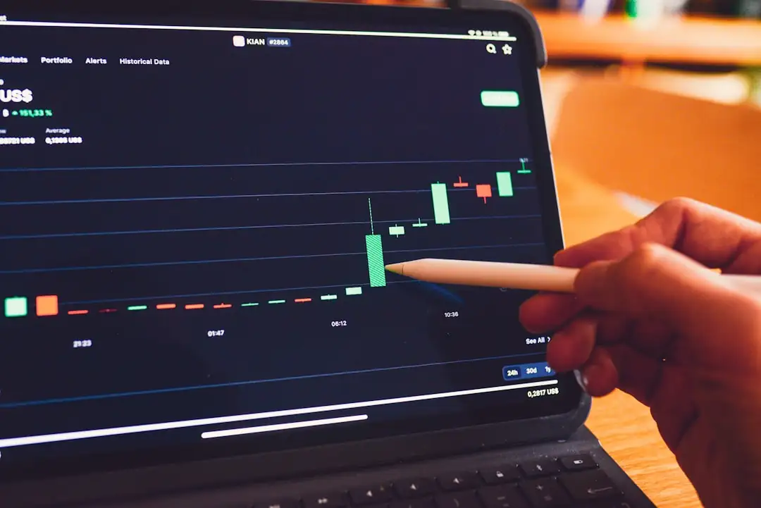 Investisseur de dos consultant une tablette devant des immeubles de bureaux dans un quartier américain.