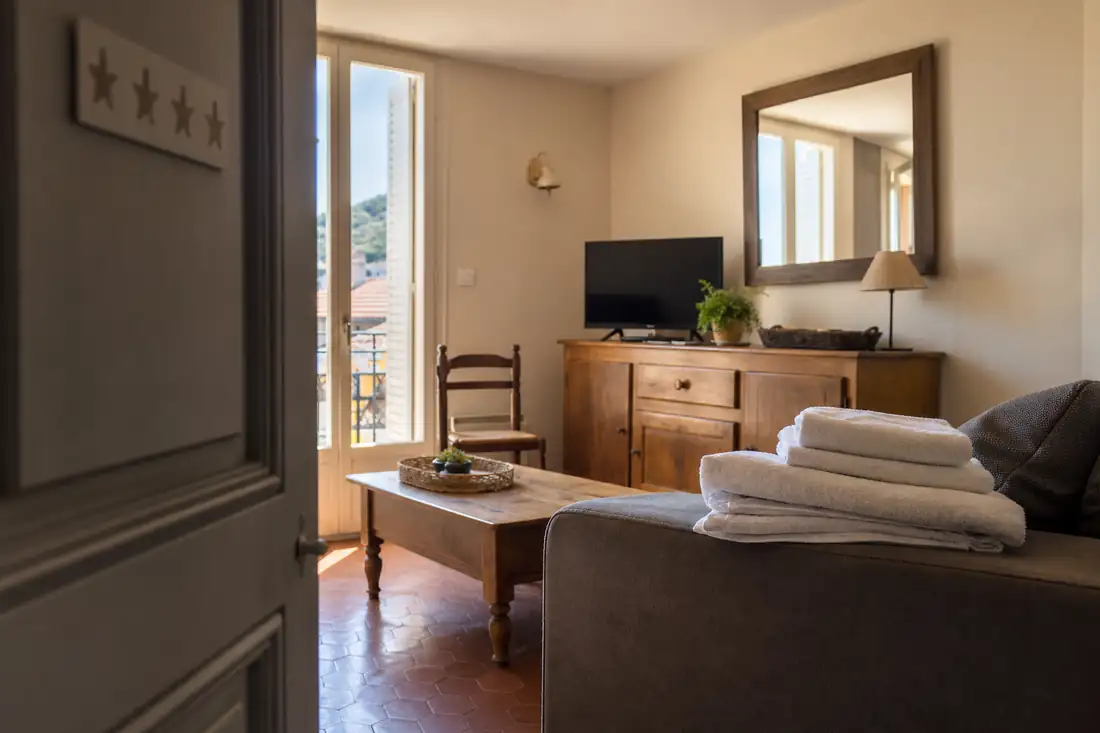Intérieur d’un meublé de tourisme classé, salon lumineux avec linge de maison préparé pour des voyageurs
