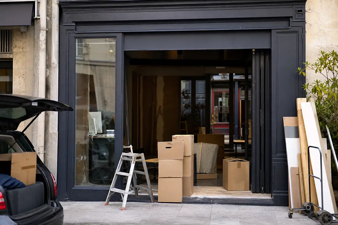 Devanture de commerce en cours de cession avec des cartons de déménagement