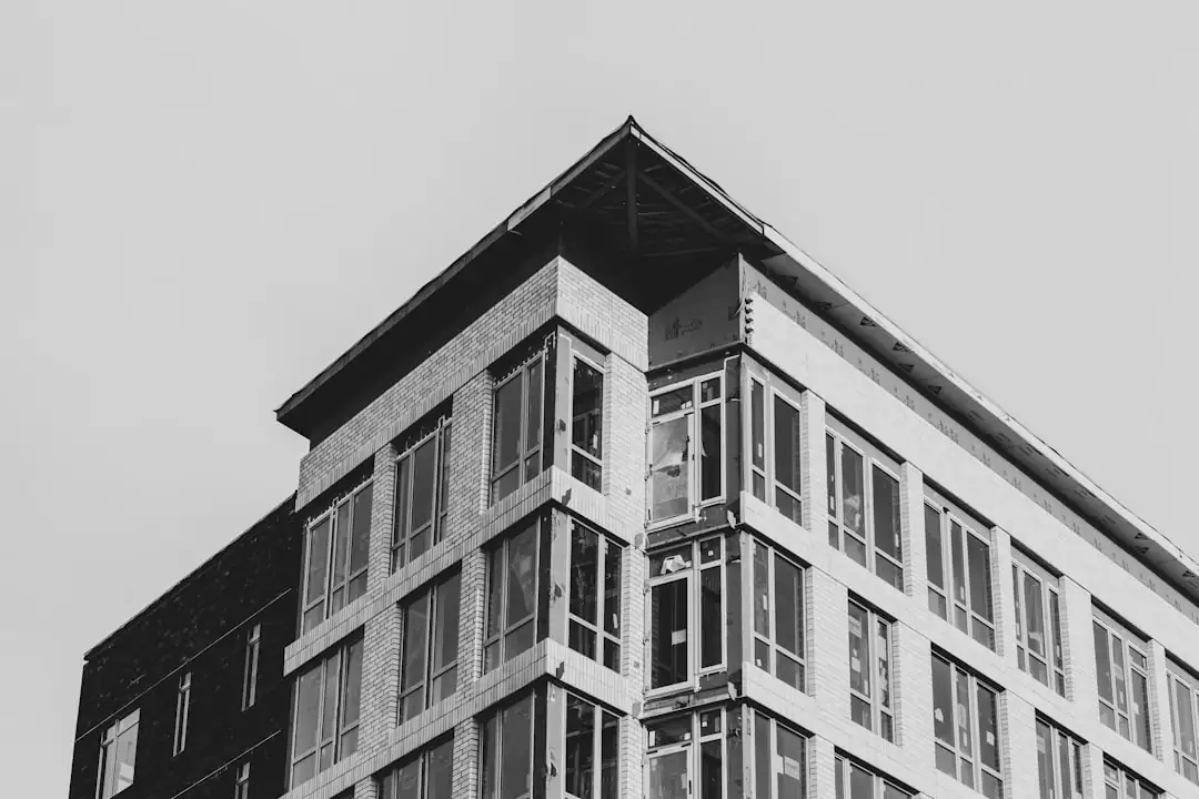 Immeuble de bureaux en rénovation avec balcons créés dans un quartier urbain desservi par les transports.