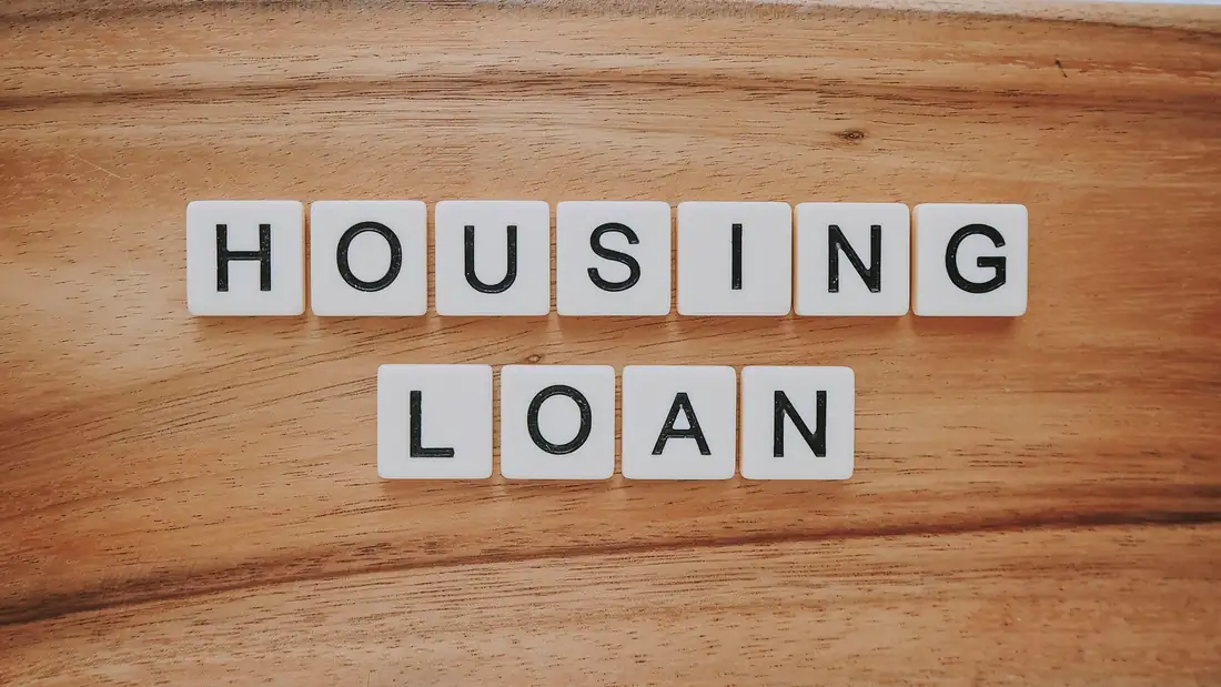 Dossier de crédit, calculatrice et clés posés sur une table lors d’un rendez-vous d’achat immobilier.