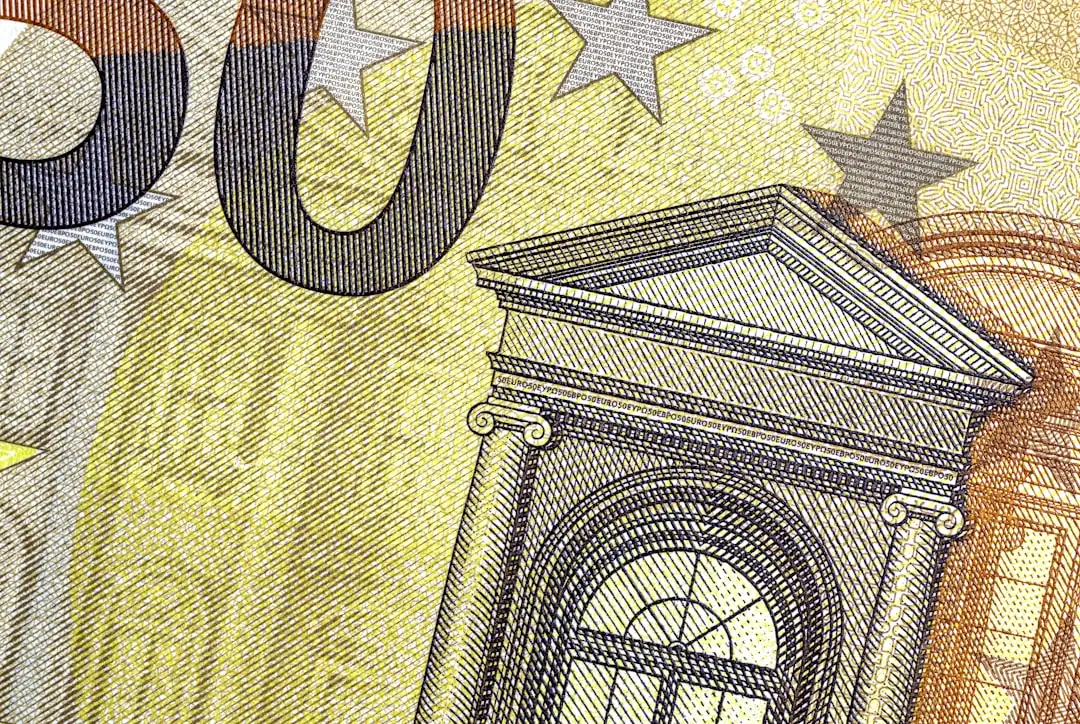 Conseillère bancaire comparant plusieurs simulations de prêt sur un bureau devant des immeubles européens.