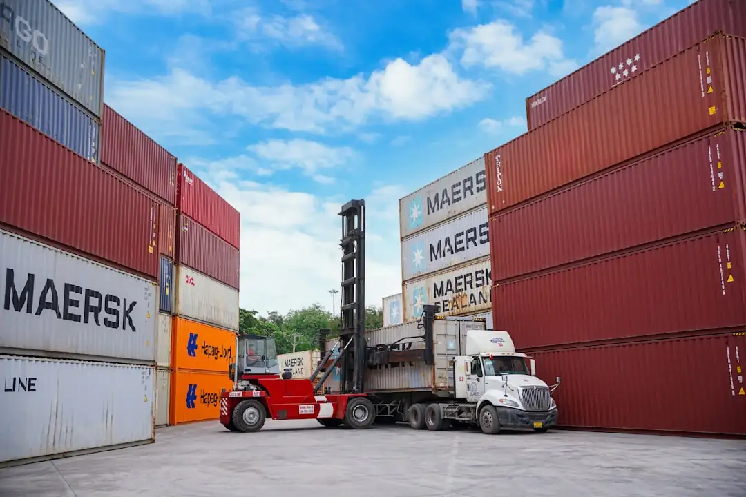 Plateforme logistique moderne avec quais de chargement, camions non marqués et aire de manœuvre dégagée.