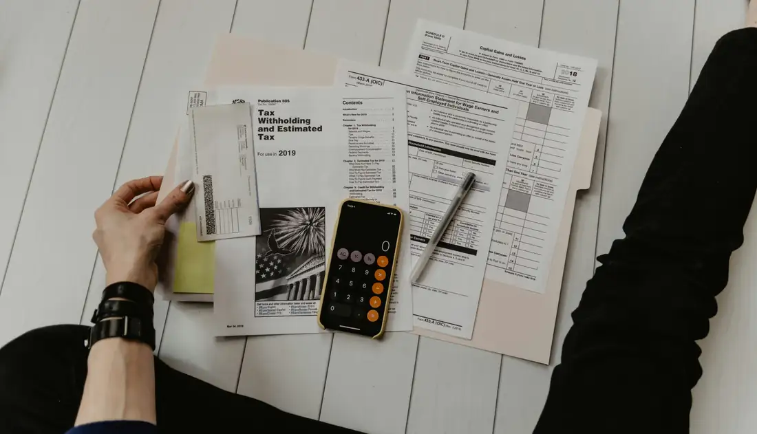Propriétaire vérifiant ses relevés de loyers, factures et documents fiscaux avant sa déclaration annuelle.