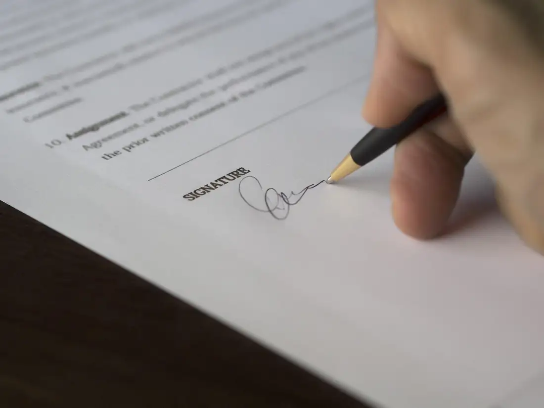 Dossier de financement immobilier et calculatrice sur une table, devant une fenêtre donnant sur un quartier résidentiel.
