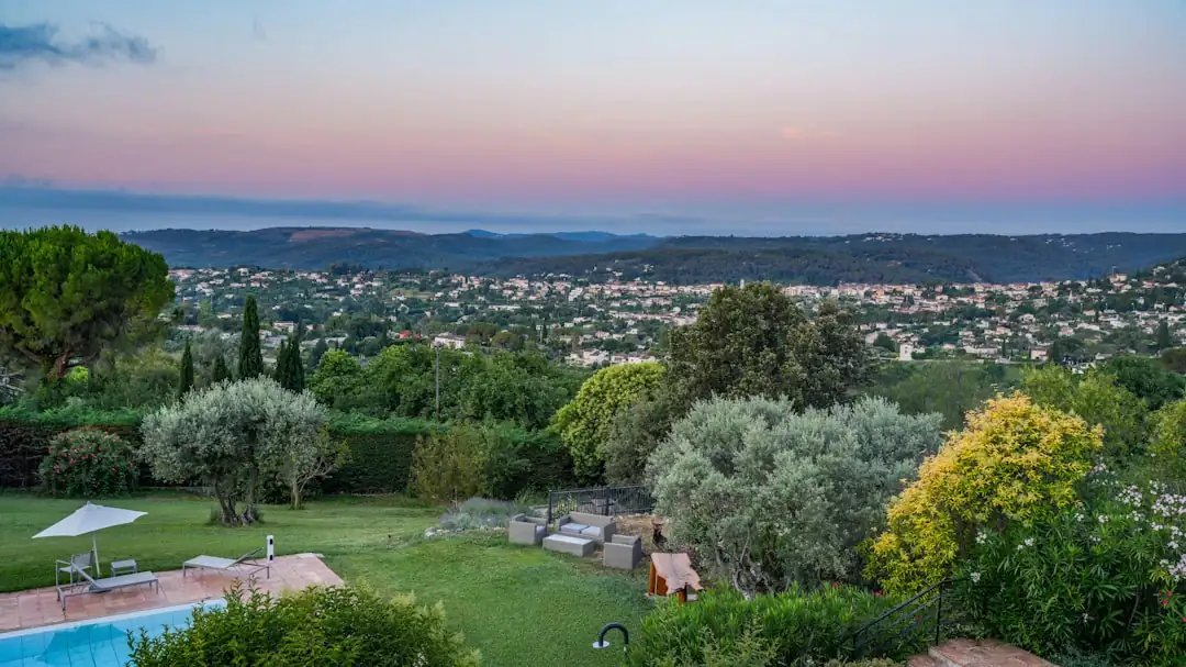 Mas provençal en pierre avec cour ombragée, oliviers et collines entre les Alpilles et le Luberon.