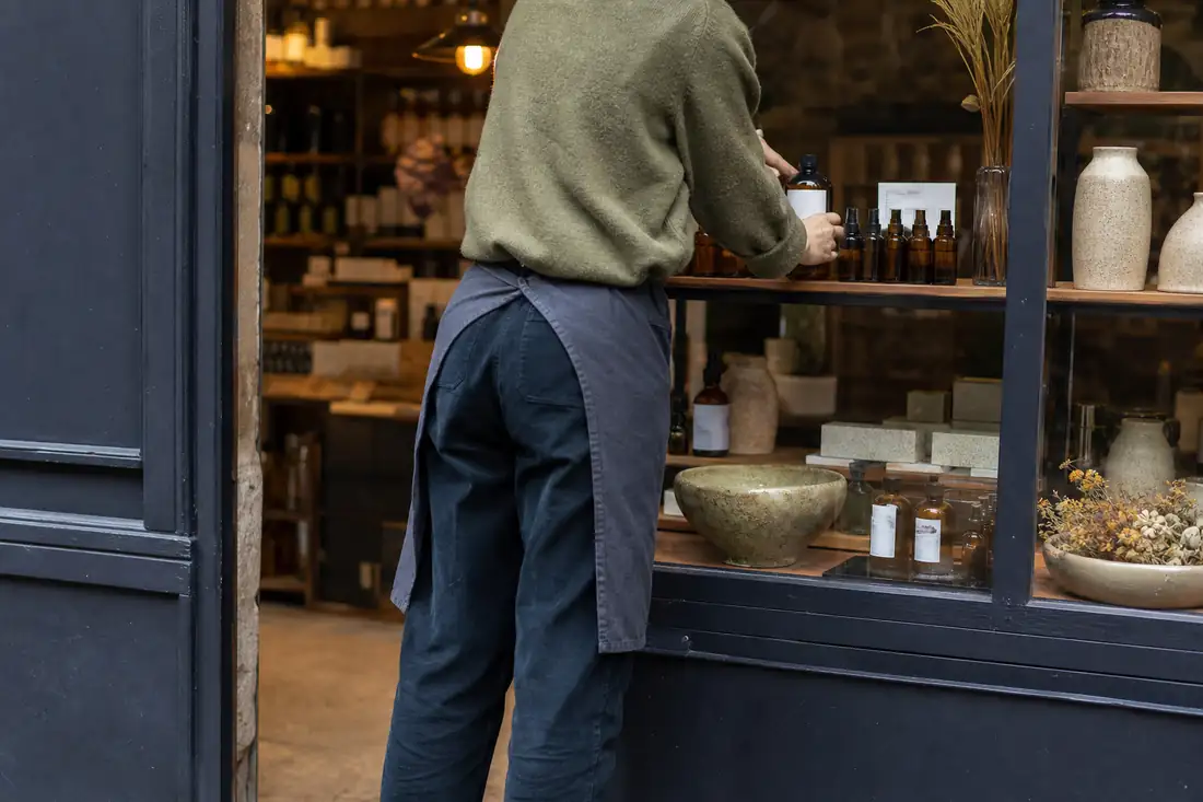 Commerçant réorganisant sa vitrine pour développer une nouvelle activité dans son local commercial