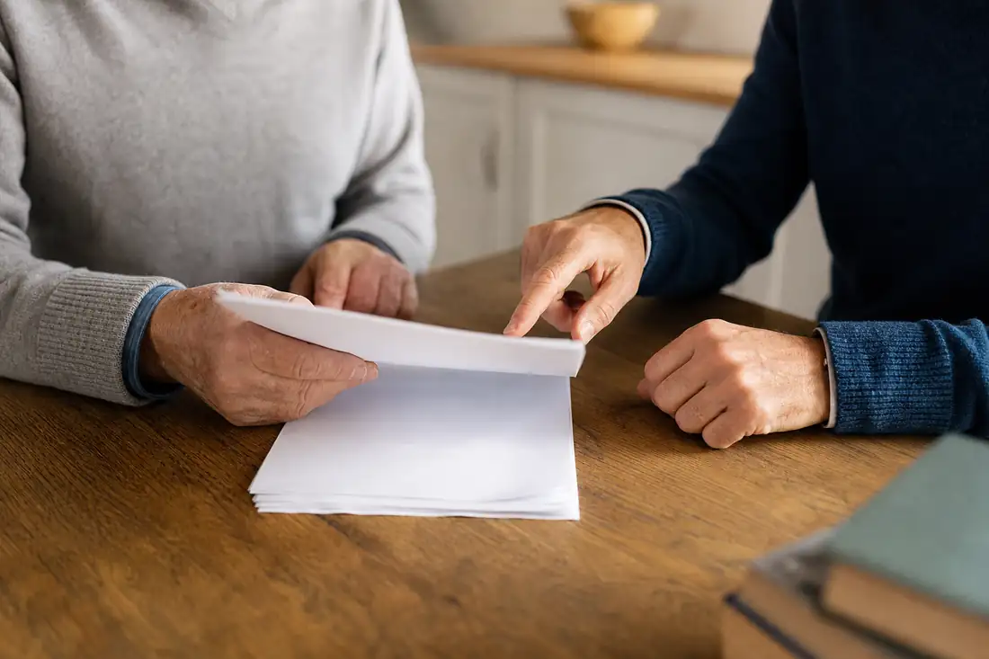 Parent et enfant examinant un acte de donation immobilière avec charge à la table familiale
