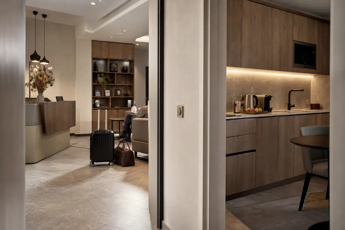 Réception contemporaine d’un aparthotel français avec espace de travail et cuisines discrètes dans les studios.