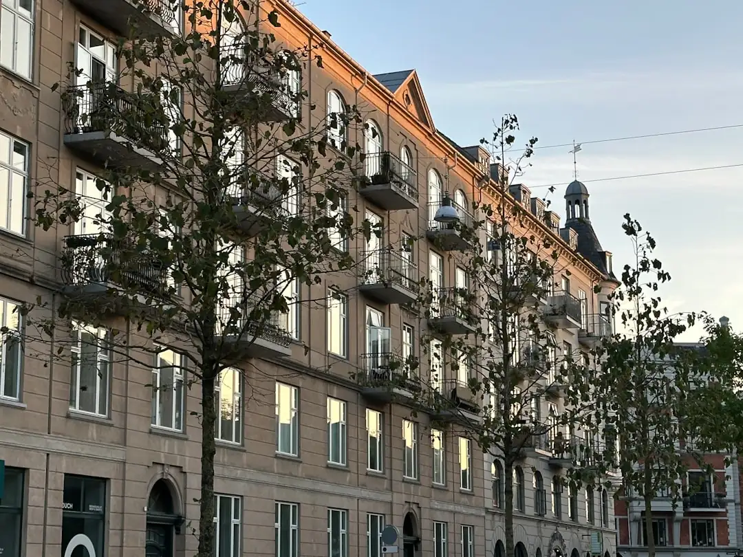 Immeuble résidentiel en briques dans un quartier néerlandais, avec vélos et analyste de dos devant l’entrée.