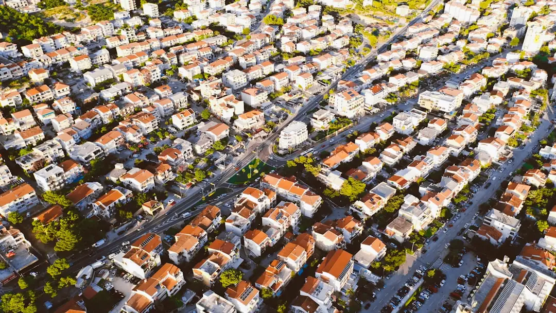 Analyste examinant des documents financiers devant les immeubles d’un quartier d’affaires français.