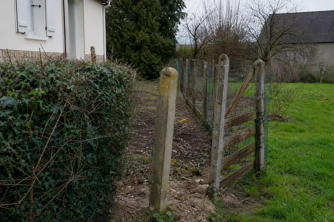 Jardin de maison individuelle avec une clôture ancienne près de la limite de propriété