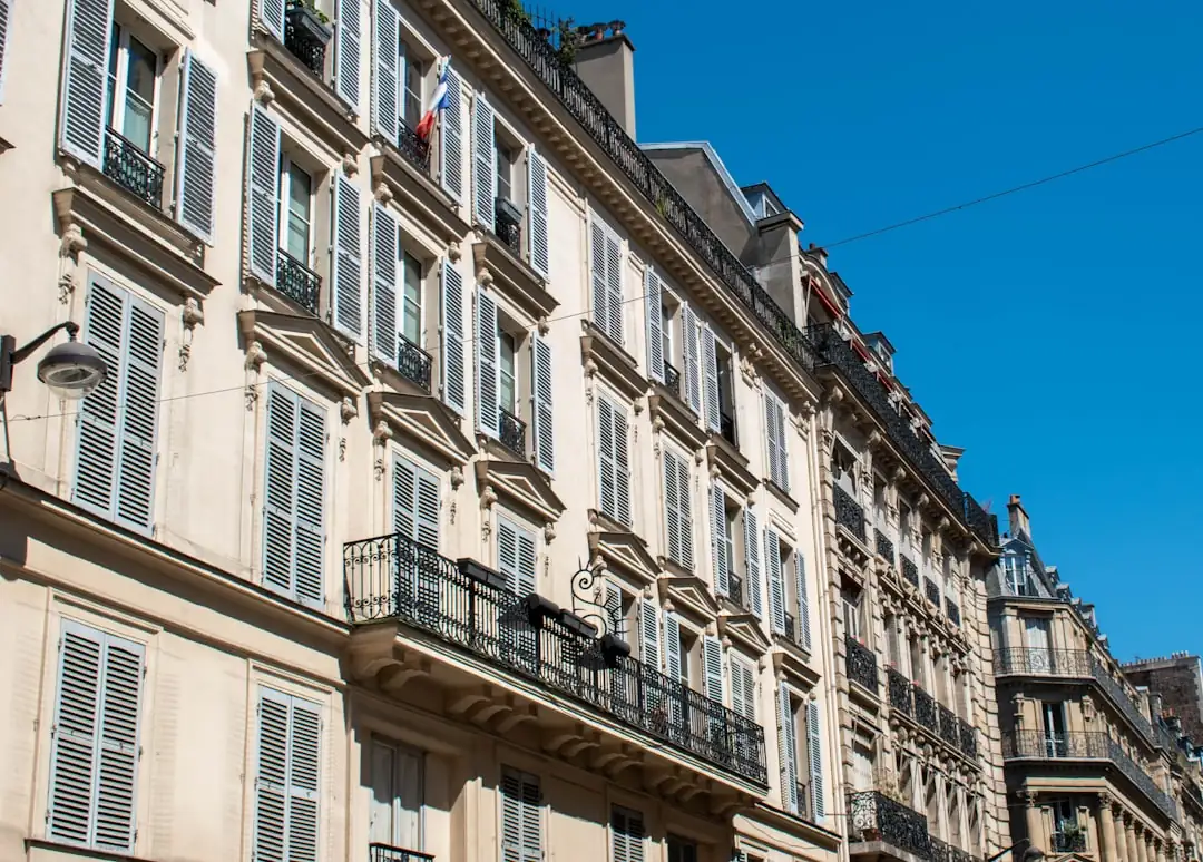 Visite d’un appartement ancien à Paris avec parquet, grandes fenêtres et plans de financement en main.