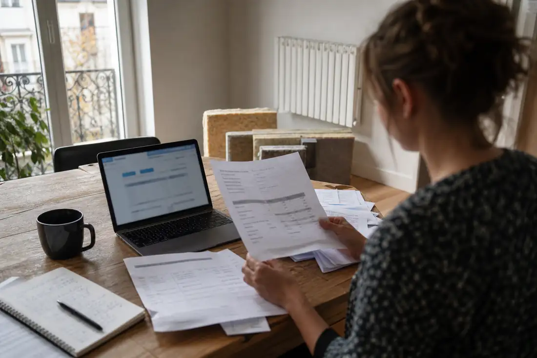 Propriétaire vérifiant factures et justificatifs de rénovation énergétique avant une demande d’aide.