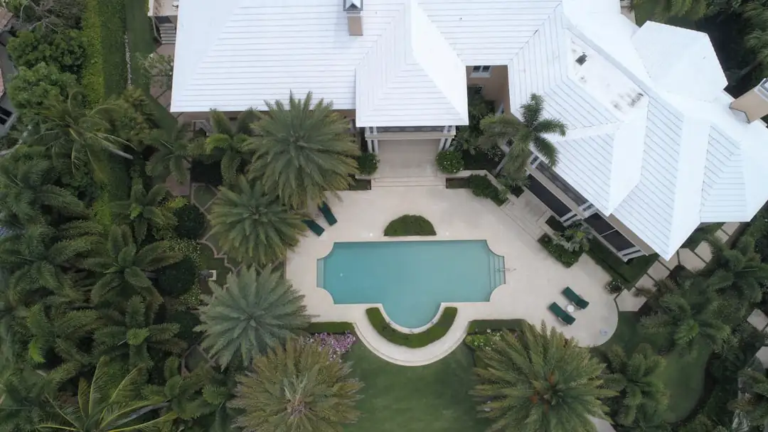Villas contemporaines et terrasses d’un quartier résidentiel haut de gamme face à une marina au coucher du soleil.
