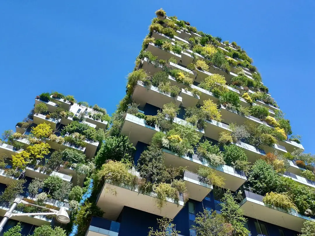 Immeuble de bureaux suisse rénové avec façade vitrée, panneaux solaires, végétation et stationnement vélo.