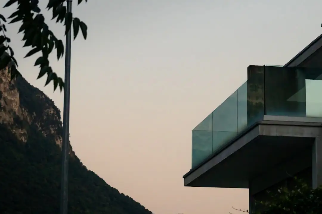 Investisseur consultant des documents de copropriété dans un appartement face à une station de montagne enneigée.