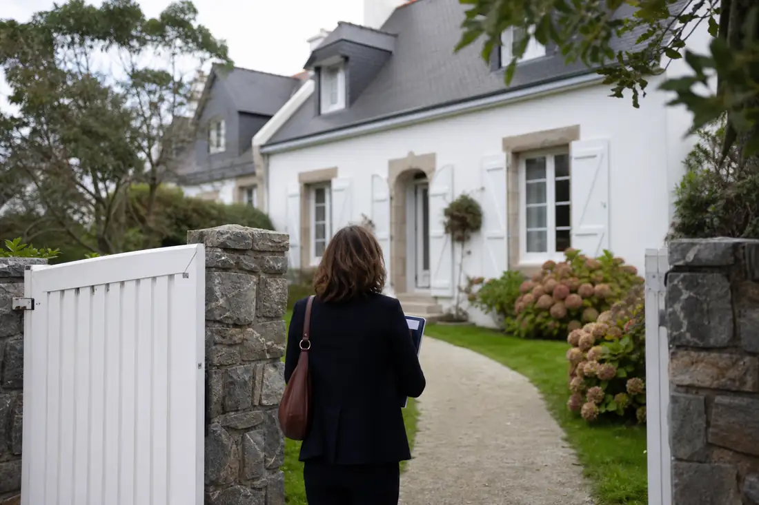 Résidence secondaire près du littoral avec portail ouvert lors d’une visite immobilière en automne.
