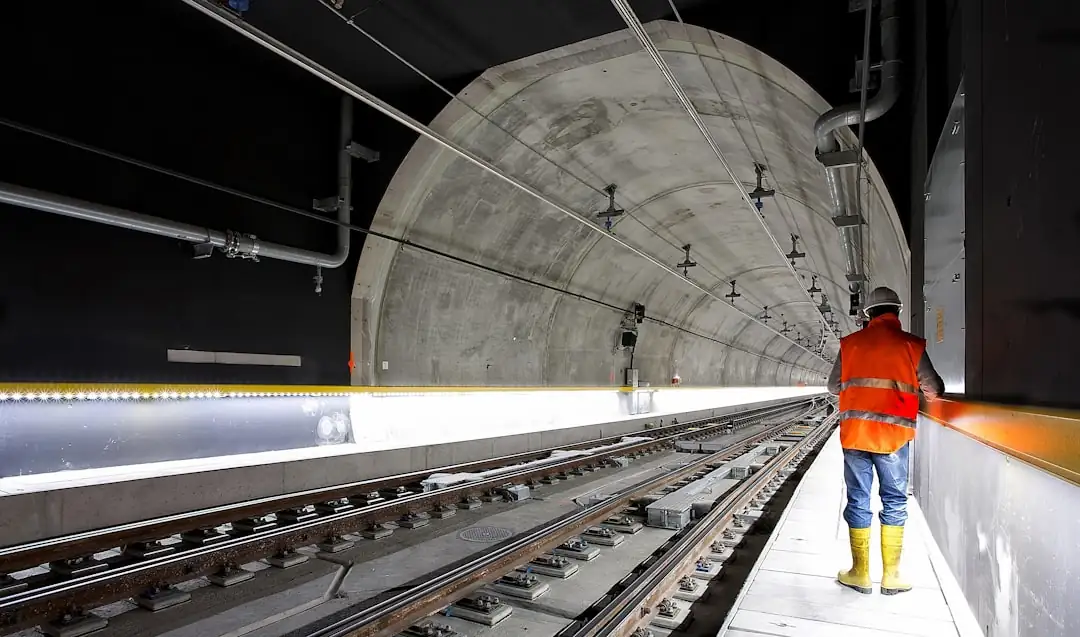 Grue et immeubles résidentiels en chantier, avec matériaux stockés et activité réduite en périphérie urbaine.