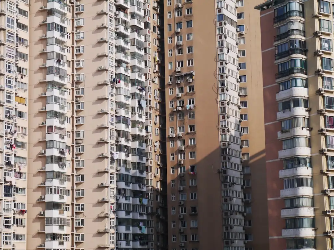 Locataire visitant un appartement lumineux avec dossier de financement dans un quartier résidentiel dense.