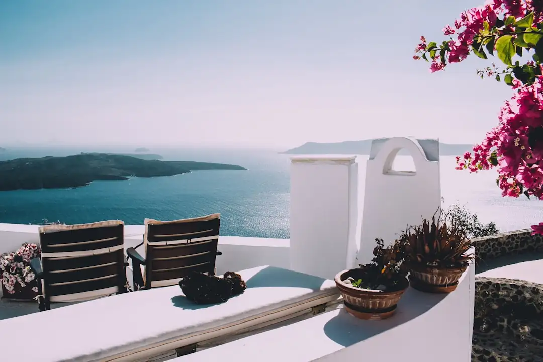 Terrasse d’un appartement de location saisonnière avec vue dégagée vers une plage et le front de mer.
