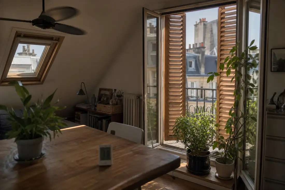 Appartement au dernier étage protégé par des volets extérieurs face à une forte chaleur estivale en ville.