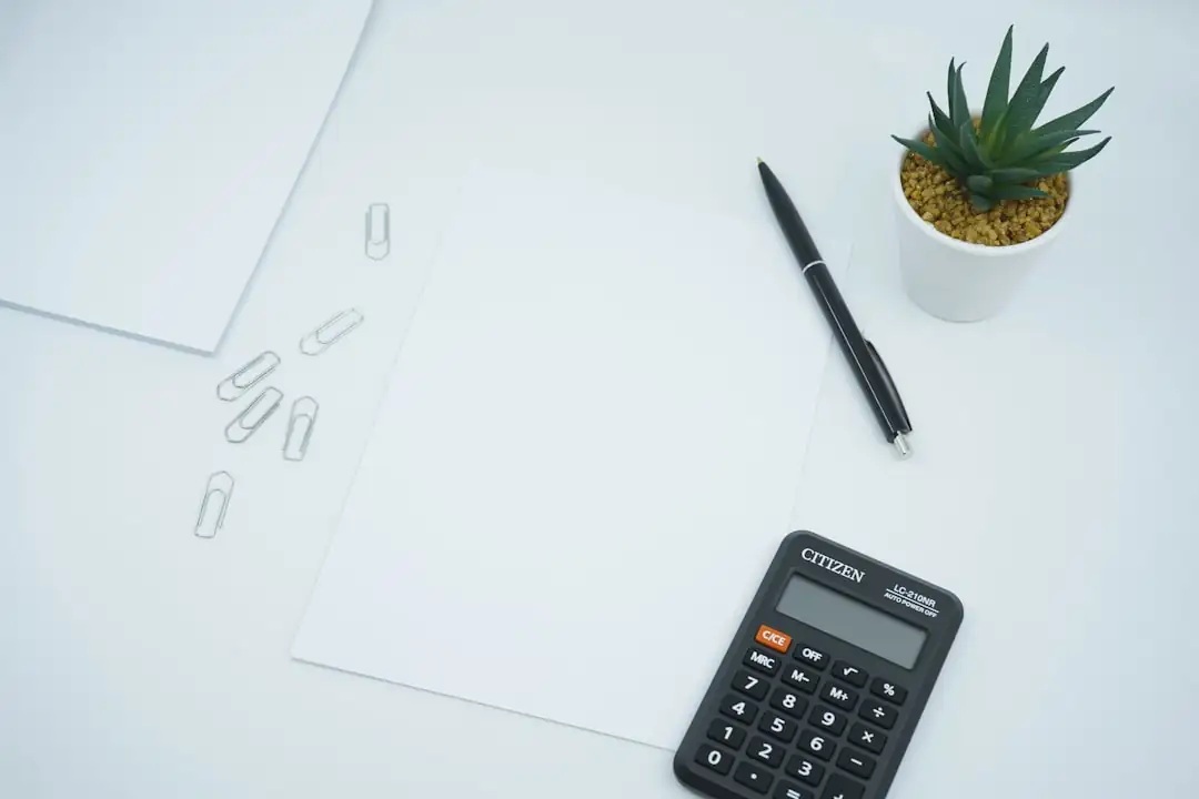 Couple examinant des documents de crédit et un budget sur une table de cuisine, sans visage identifiable.