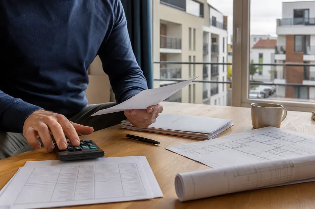 Investisseur examinant les documents fiscaux et financiers d’un projet d’achat locatif en appartement.
