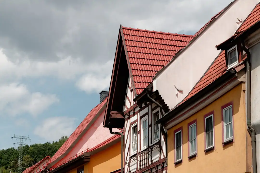Appartement sous les toits exposé au soleil avec volets fermés et dossier de rénovation énergétique sur table.