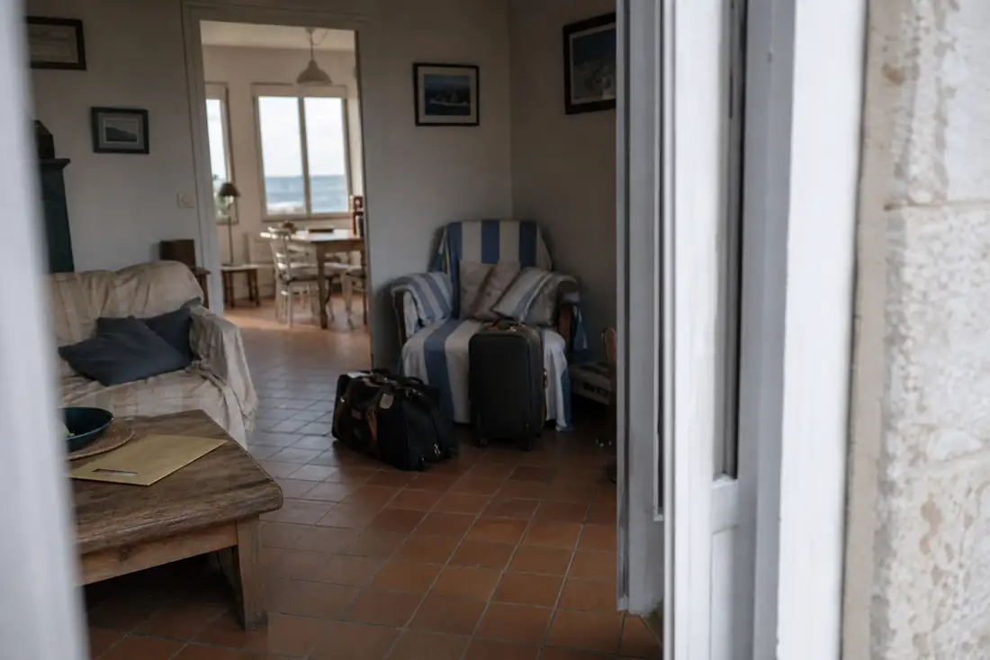 Intérieur meublé d’une résidence secondaire avec un courrier fiscal posé sur une table en bois.