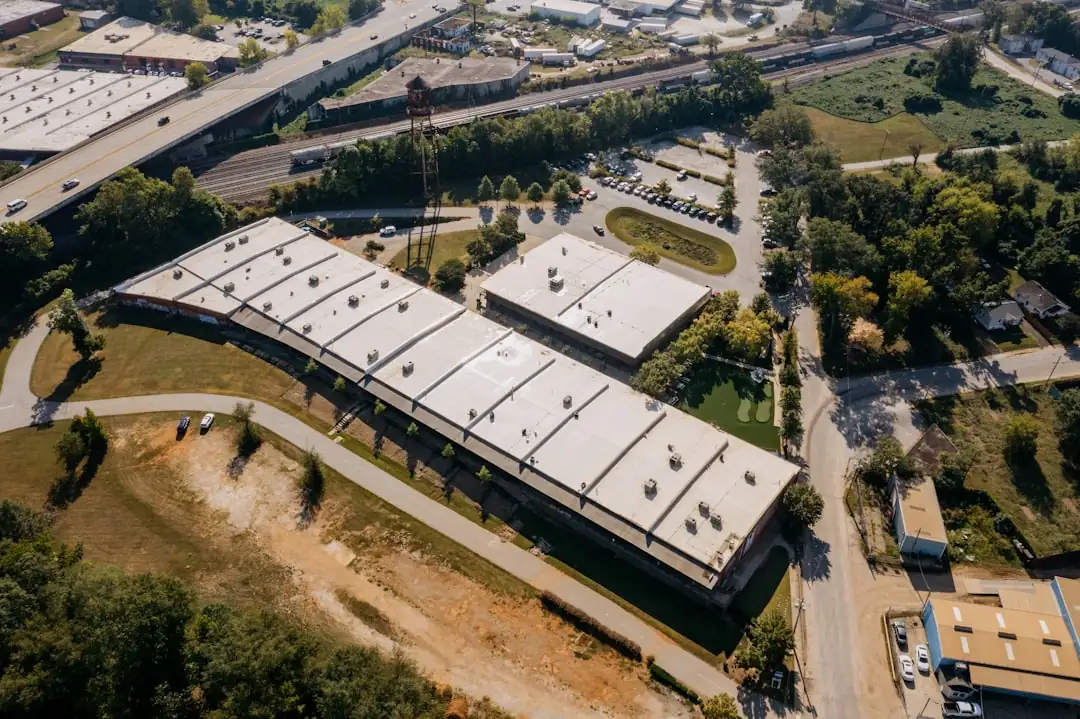 Entrepôt logistique moderne avec quais de chargement et cour de manœuvre pour poids lourds à l’aube.