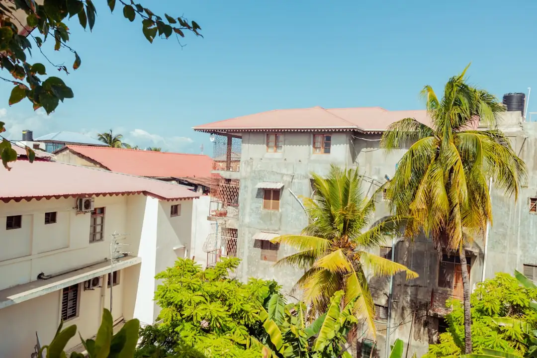 Villa caribéenne avec volets anticycloniques sur une colline, face à une baie tropicale et à la mer.