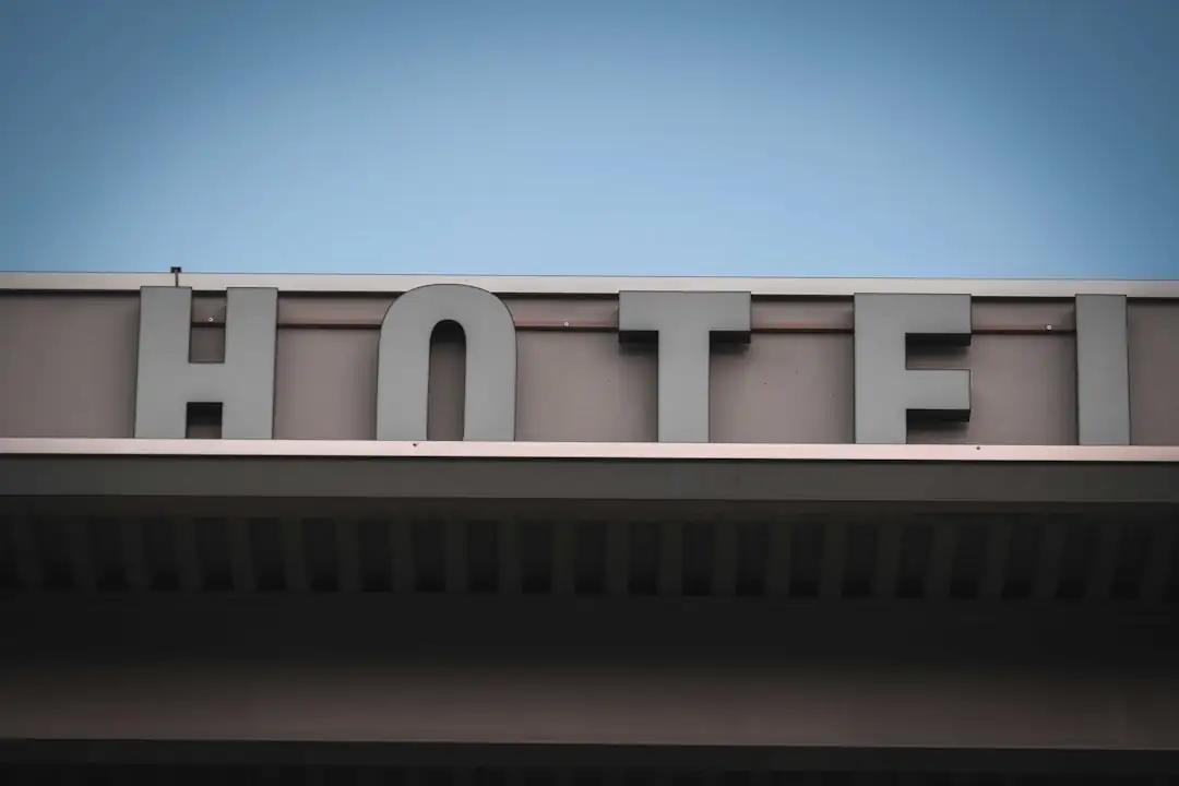 Investisseur examinant plans et documents financiers dans le hall lumineux d’un hôtel urbain contemporain.