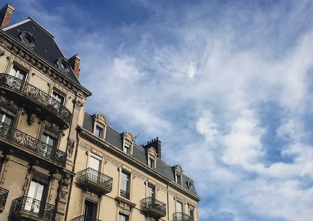 Immeubles de bureaux rénovés et voie de tramway dans un quartier d’affaires grenoblois face aux montagnes.