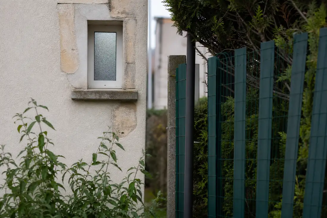 Fenêtre à vitrage dépoli près de la limite séparative d’un jardin