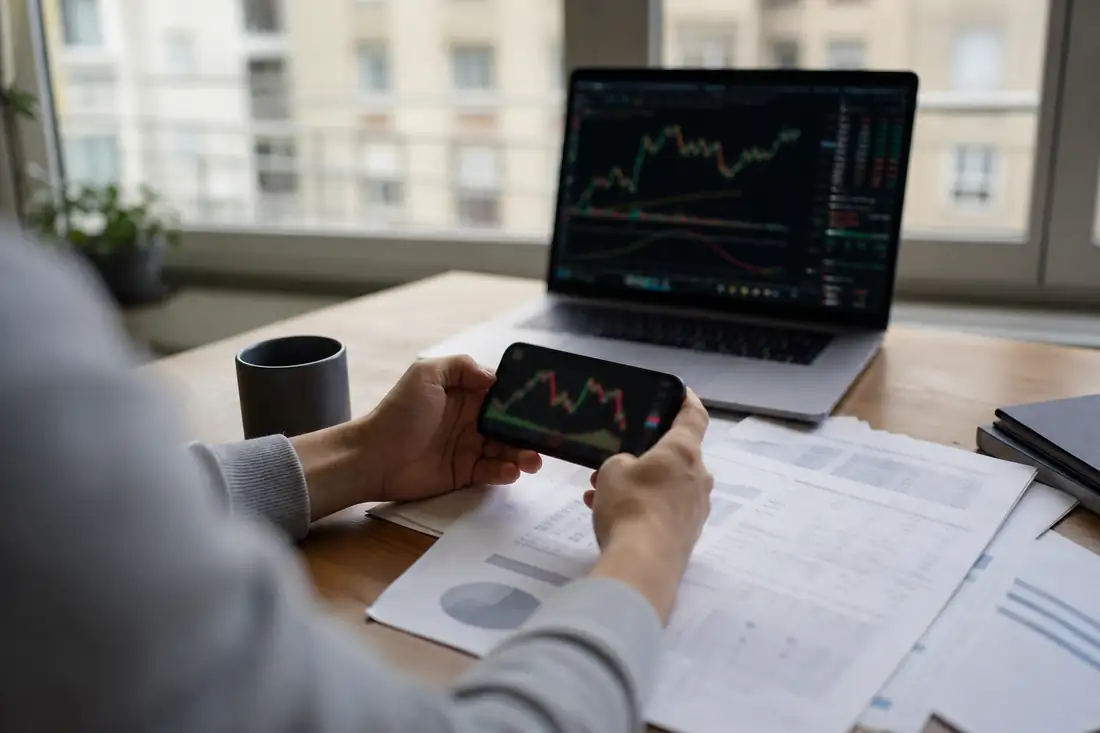 Investisseur consultant un portefeuille d’actions et des documents financiers dans un bureau d’appartement.