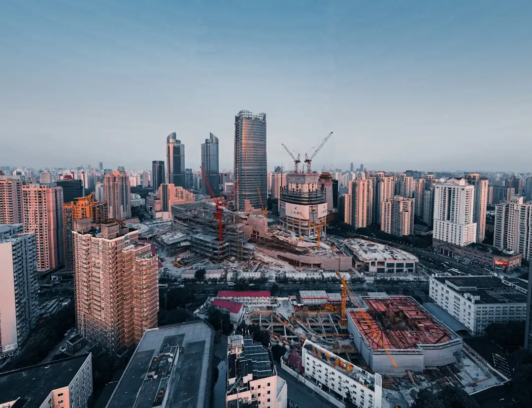 Tours résidentielles neuves et chantier partiellement actif dans un quartier urbain chinois en hiver.