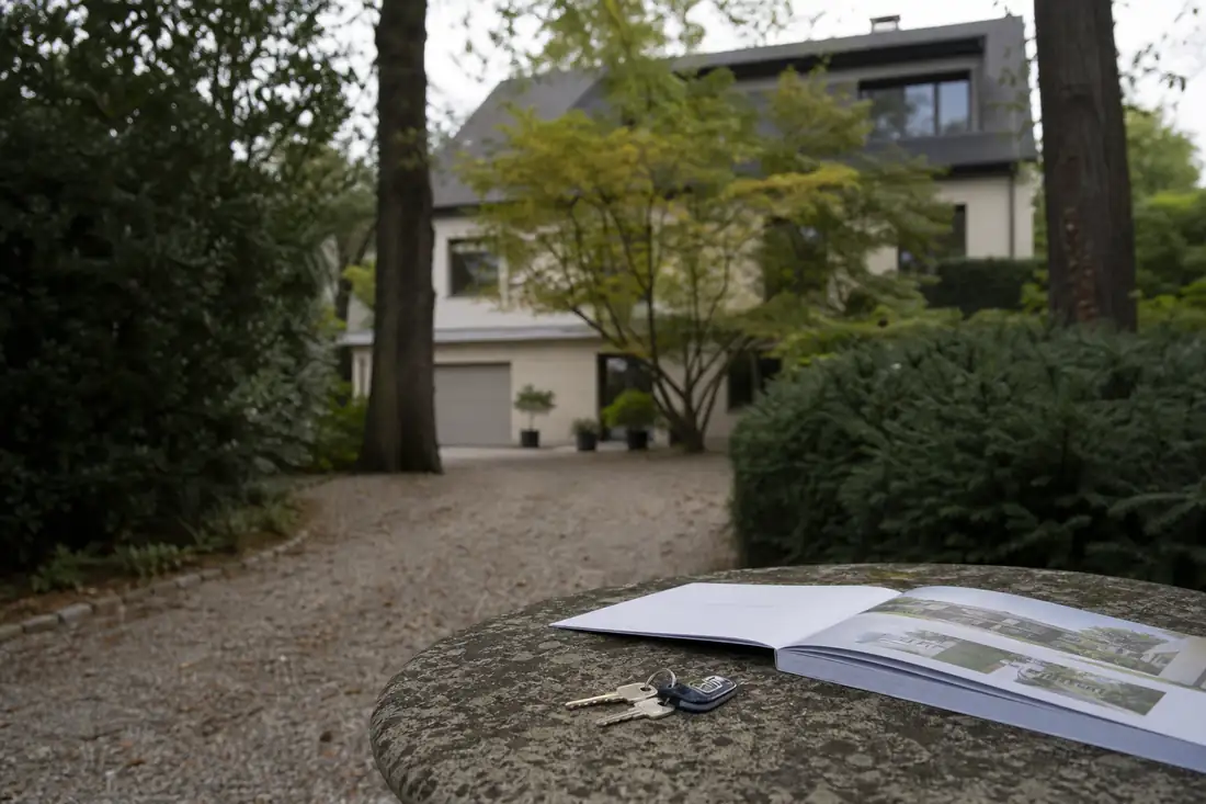 Maison contemporaine entourée d’arbres en proche couronne parisienne, observée depuis une allée privée.